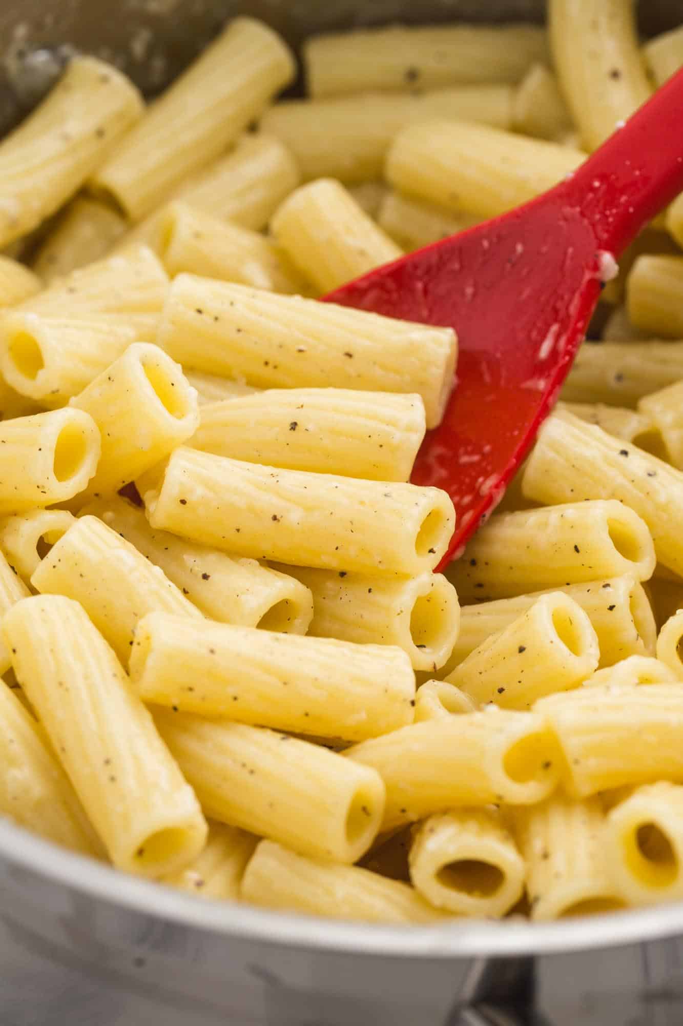 Close up shot of buttered noodles with a serving spoon
