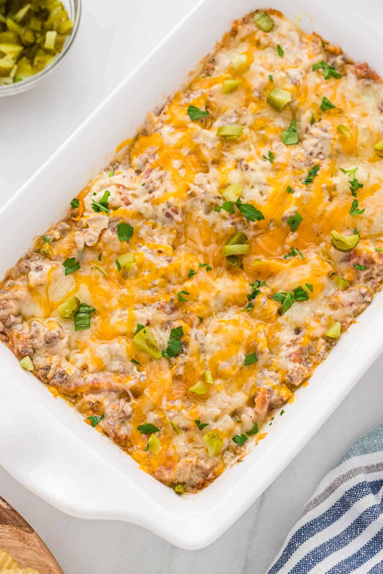Overhead shot of cheeseburger dip in a baking white dish