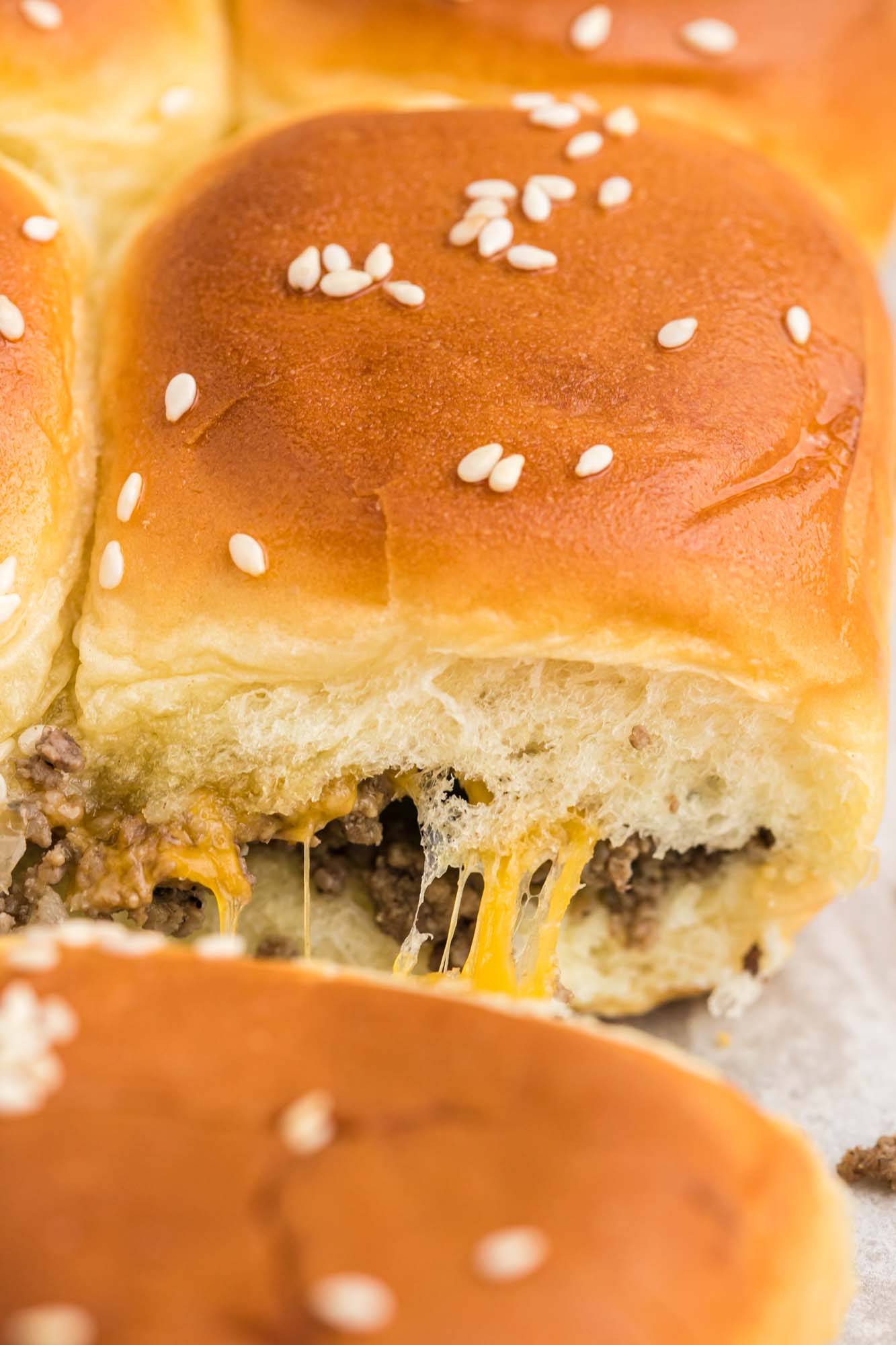 Close up shot of cheeseburger sliders with melty cheese