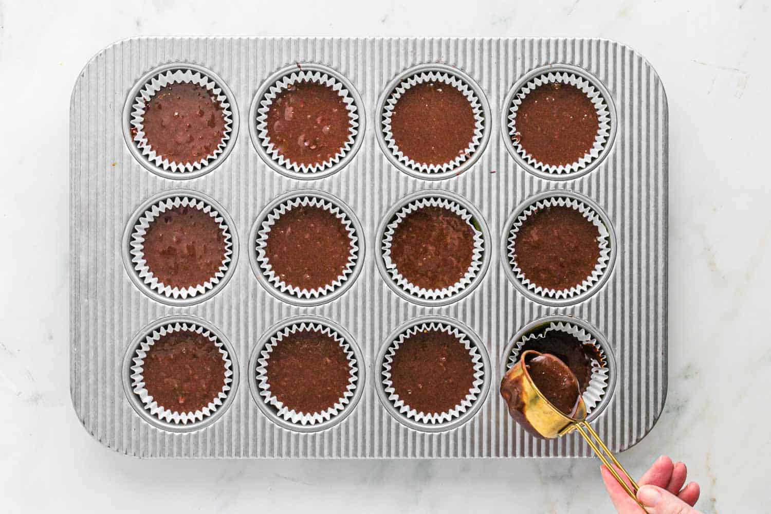 Chocolate batter in a muffin pan