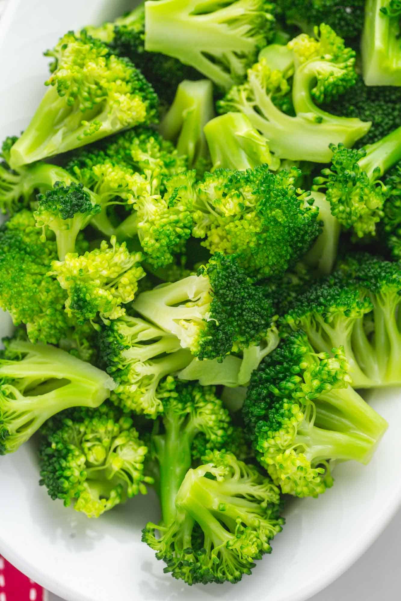 Overhead shot blanched broccoli on a white oval plate