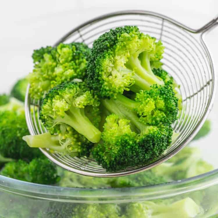 Blanched broccoli in a spider strainer