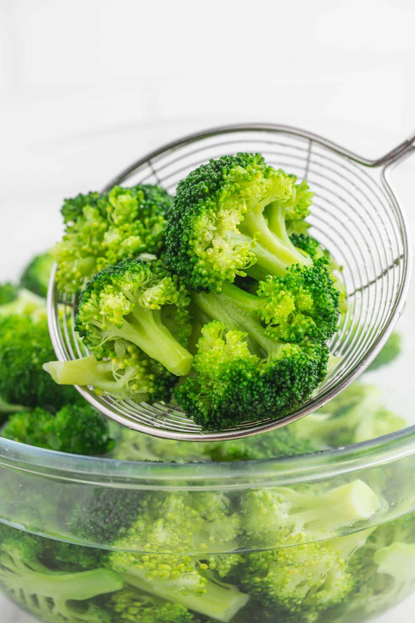 Blanched broccoli in a spider strainer