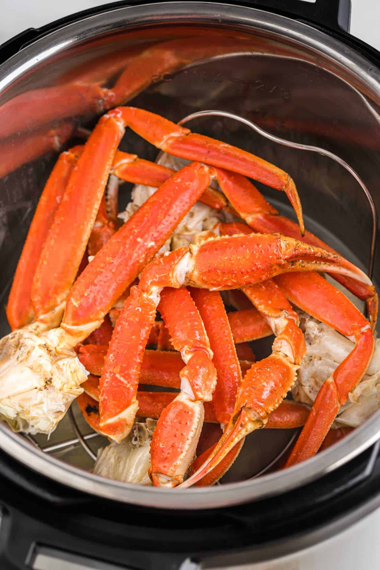 Fully cooked crab legs in the instant pot placed on a trivet