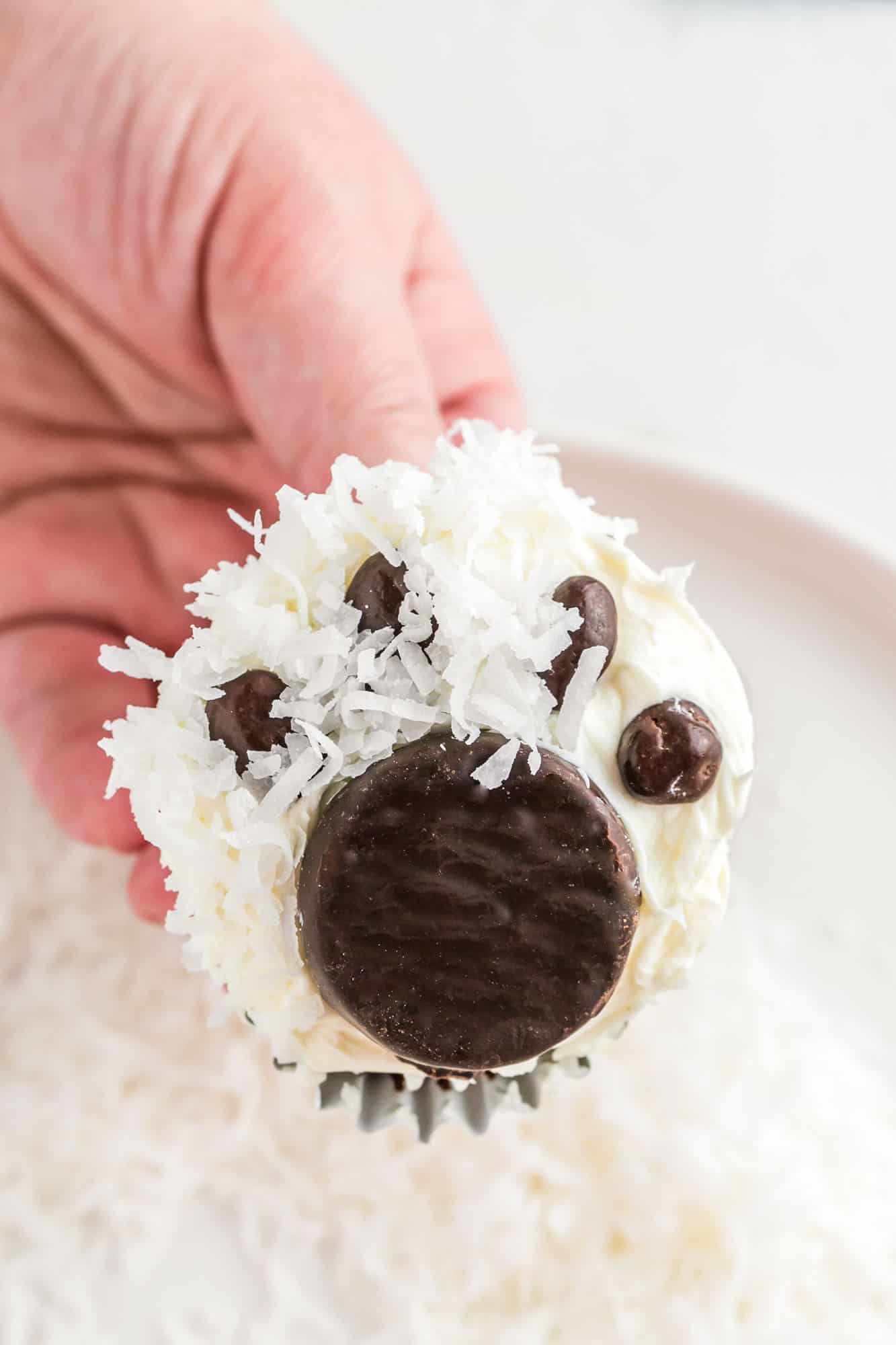 Dipping a polar bear cupcake in shredded coconut