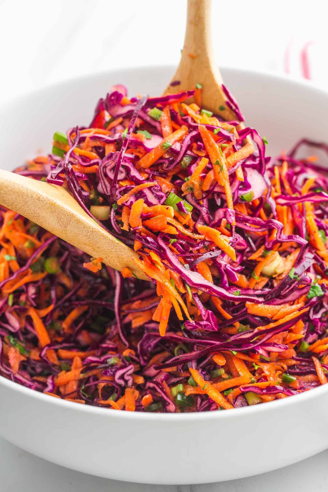 Tossing and serving red cabbage slaw using 2 wooden spoons