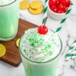 Shamrock Shake topped with whipped cream and maraschino cherry, and gold coins scattered