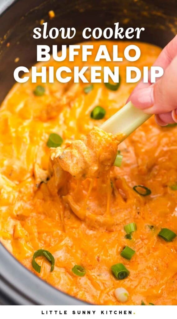 Dipping a celery stick in buffalo chicken dip in the slow cooker. With overlay text that says "slow cooker buffalo chicken dip"
