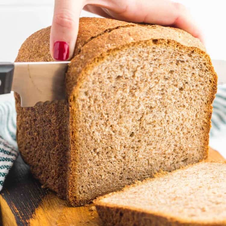 Cutting through a loaf of whole wheat bread made in the bread machine