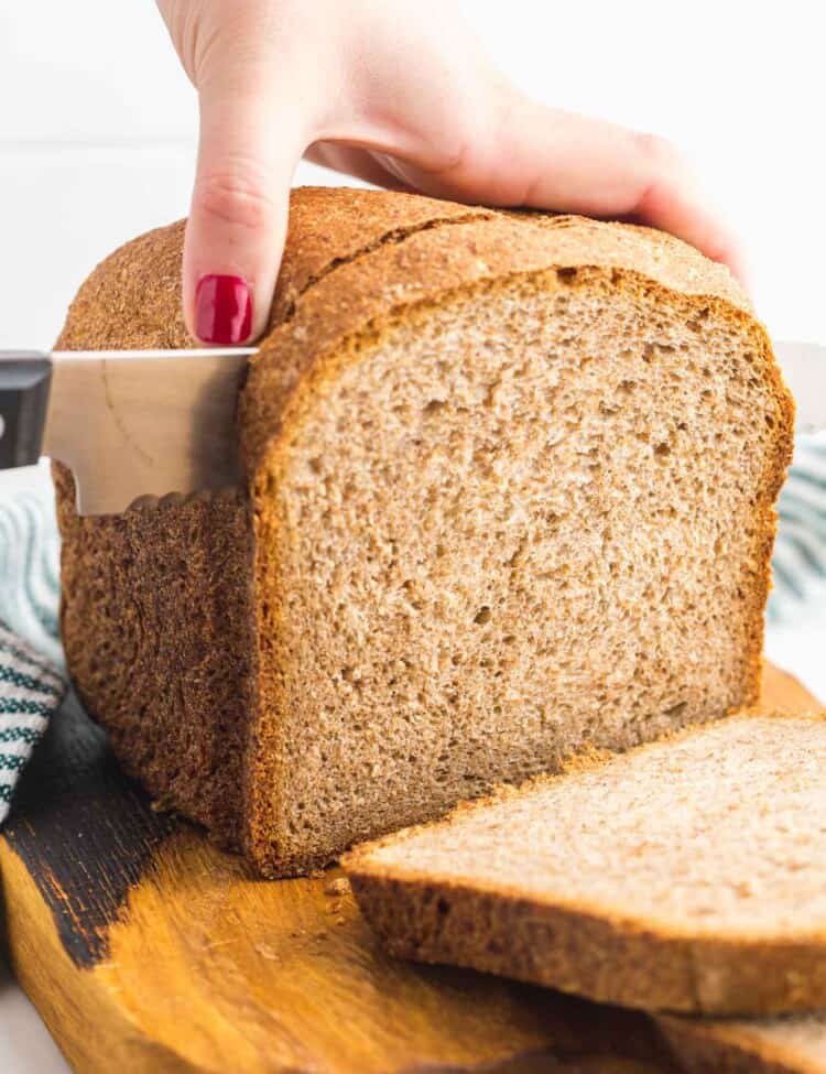 Cutting through a loaf of whole wheat bread made in the bread machine