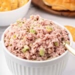 Ham salad served in a white bowl with a spoon for serving.