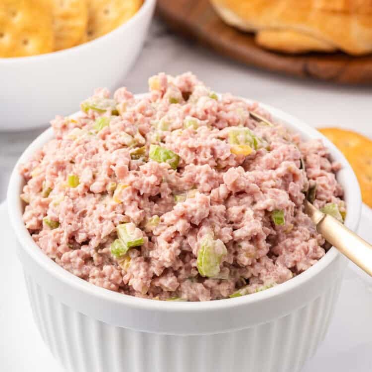 Ham salad served in a white bowl with a spoon for serving.