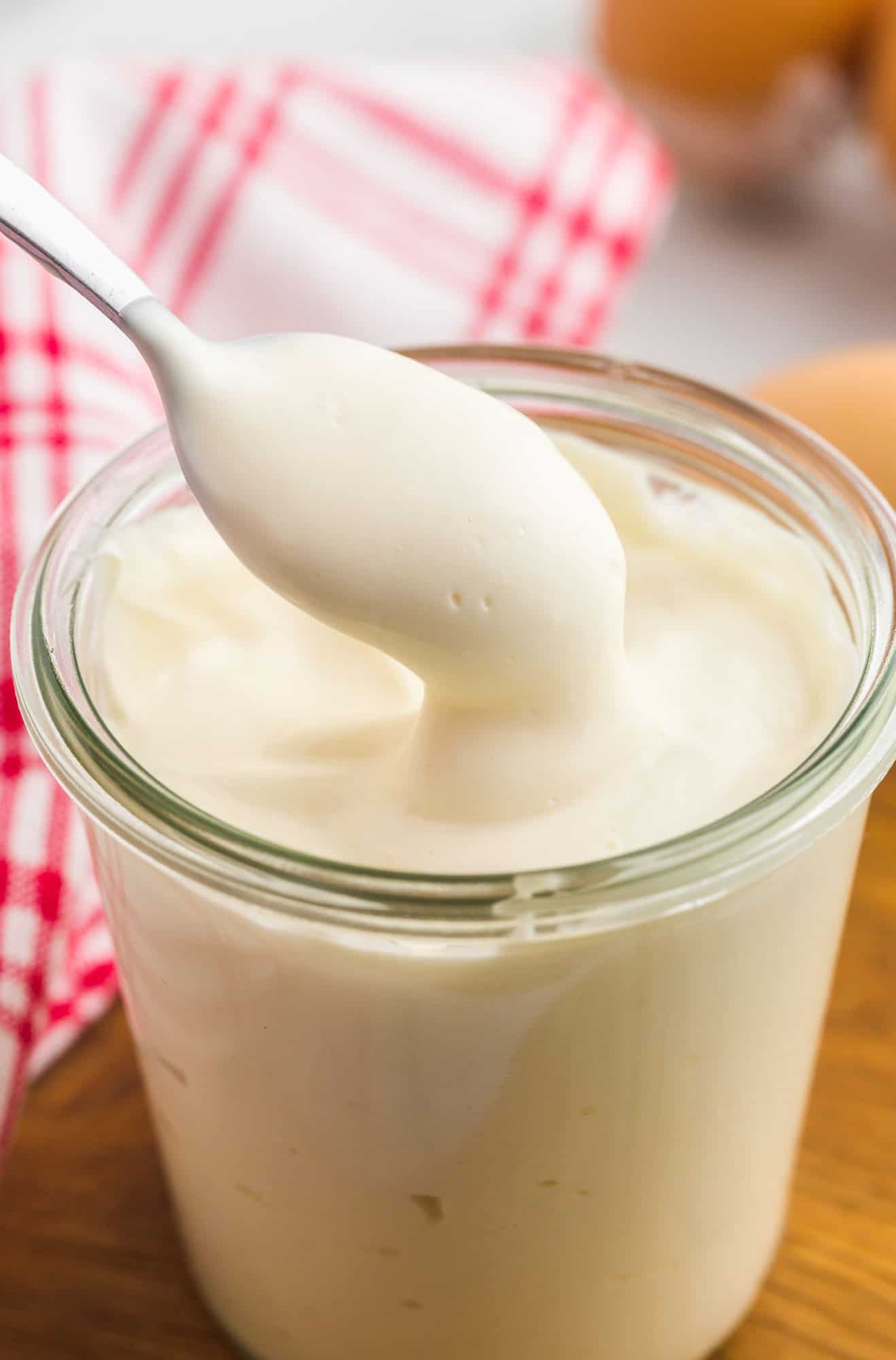 Homemade mayo in a glass Weck jar with a small spoon