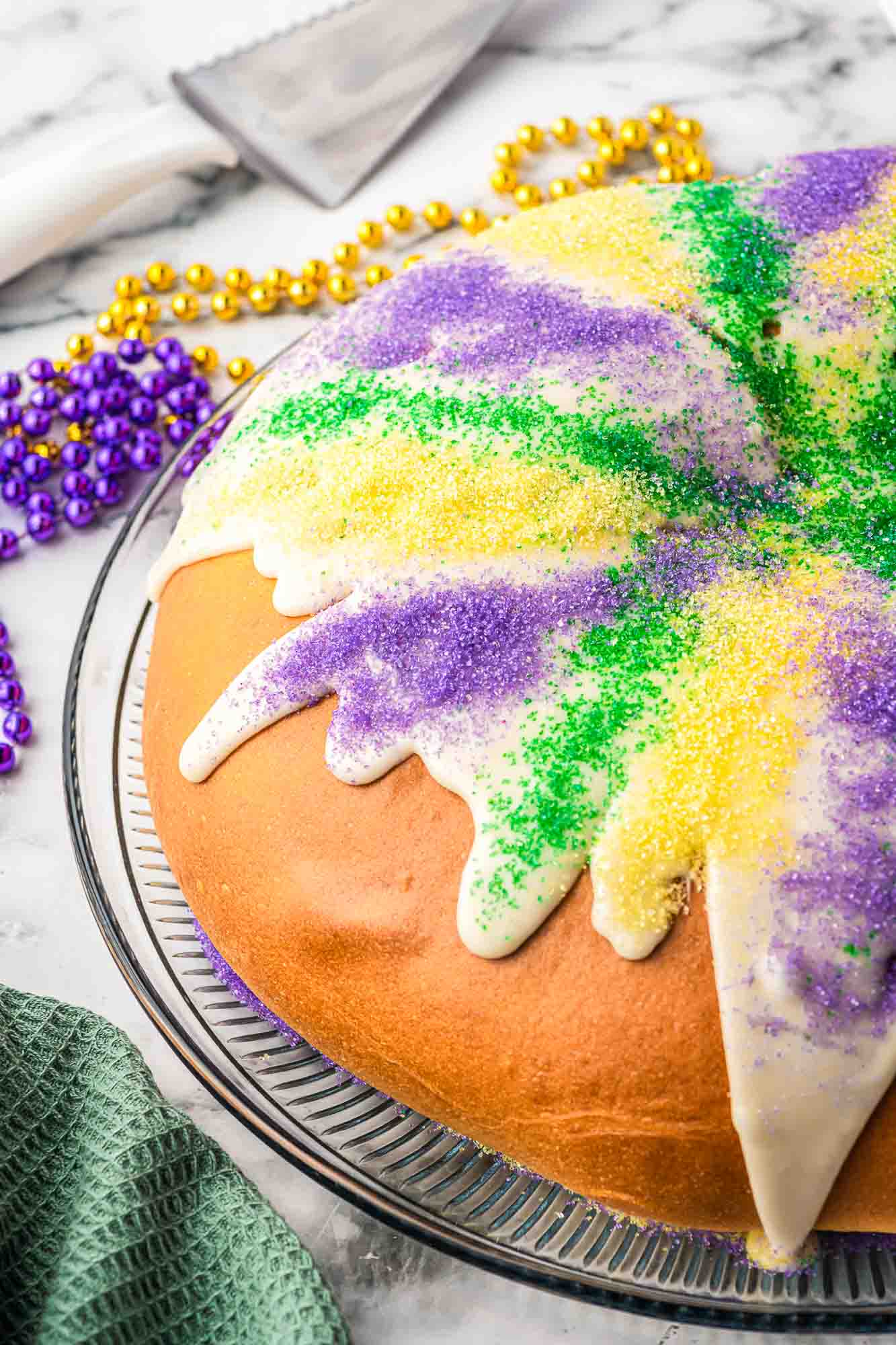 King cake decorated with icing and sanding sugar