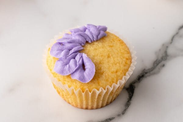 Pipping purple petals on cupcake