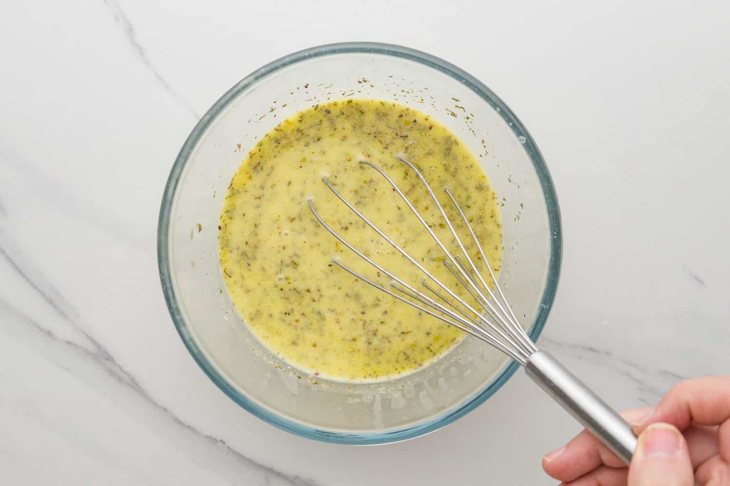 Whisking the dressing ingredients in a bowl