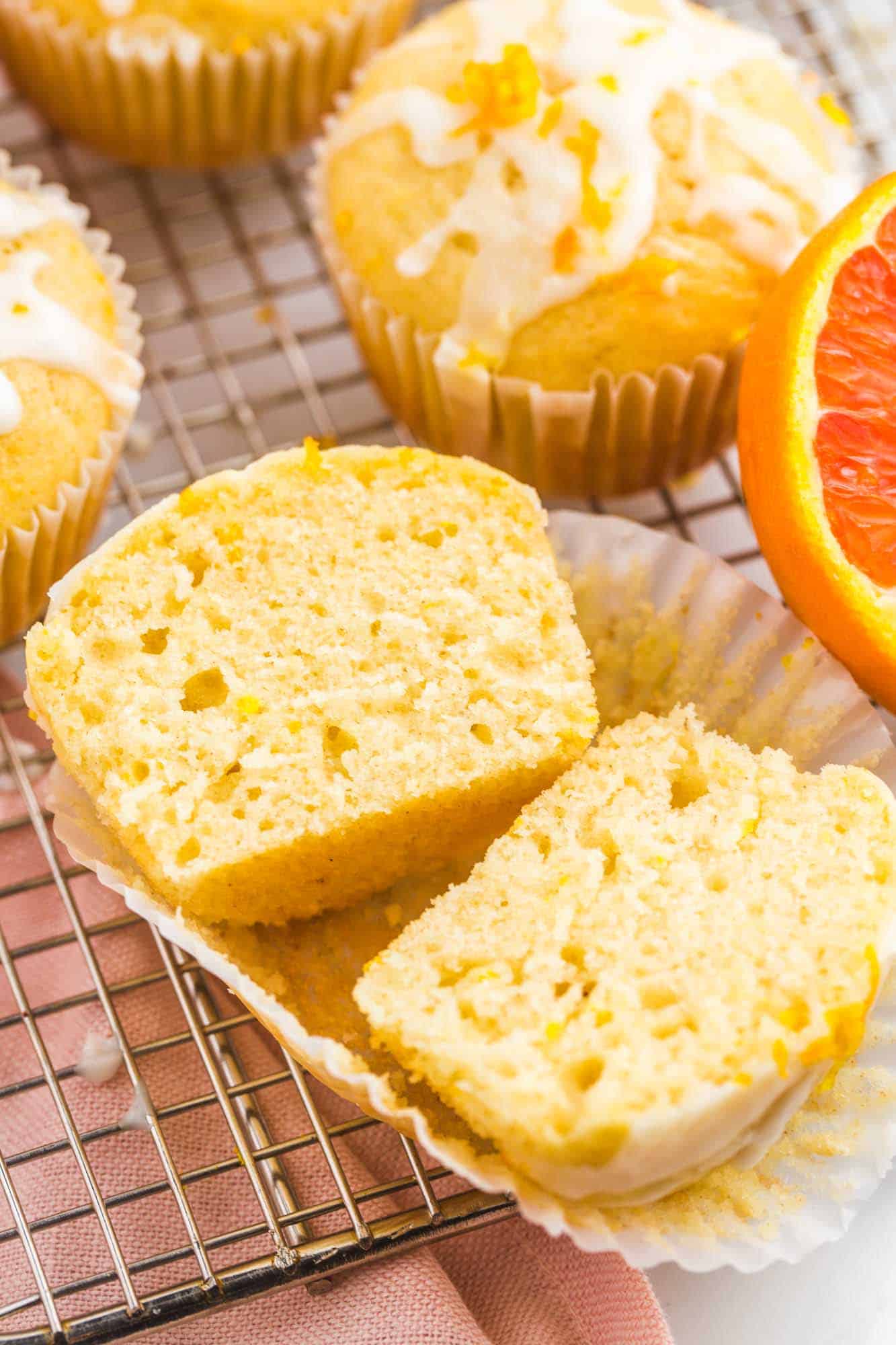 An orange muffin sliced in the middle to show the texture