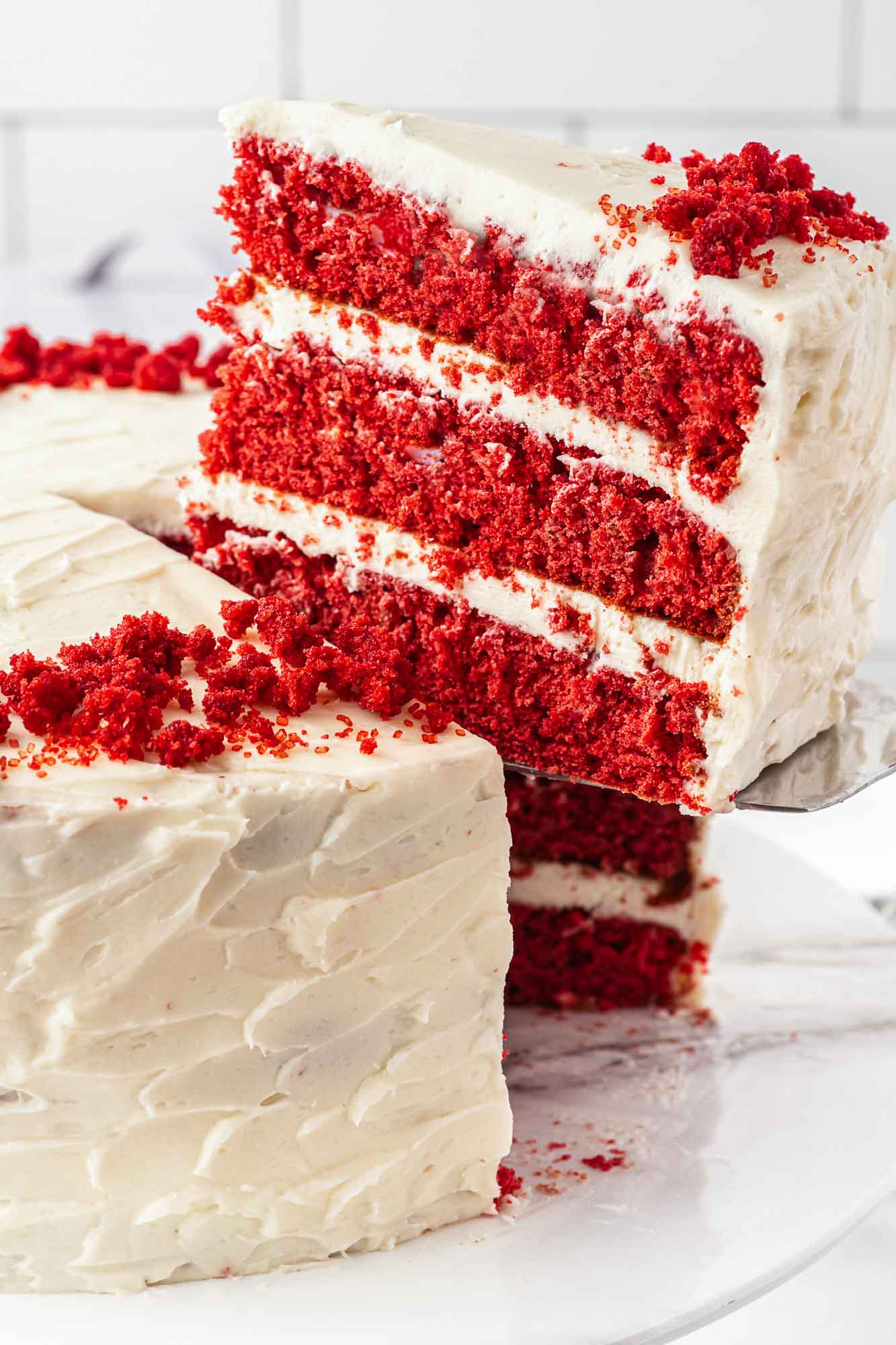 Taking a slice of red velvet cake from the whole cake.