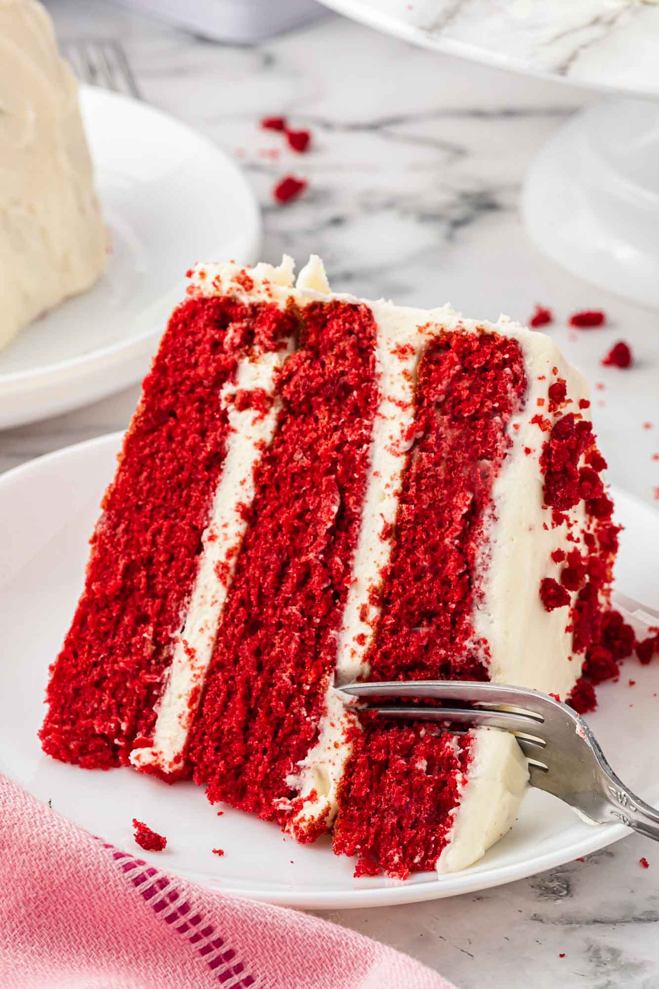 A slice of red velvet cake on a plate and a fork
