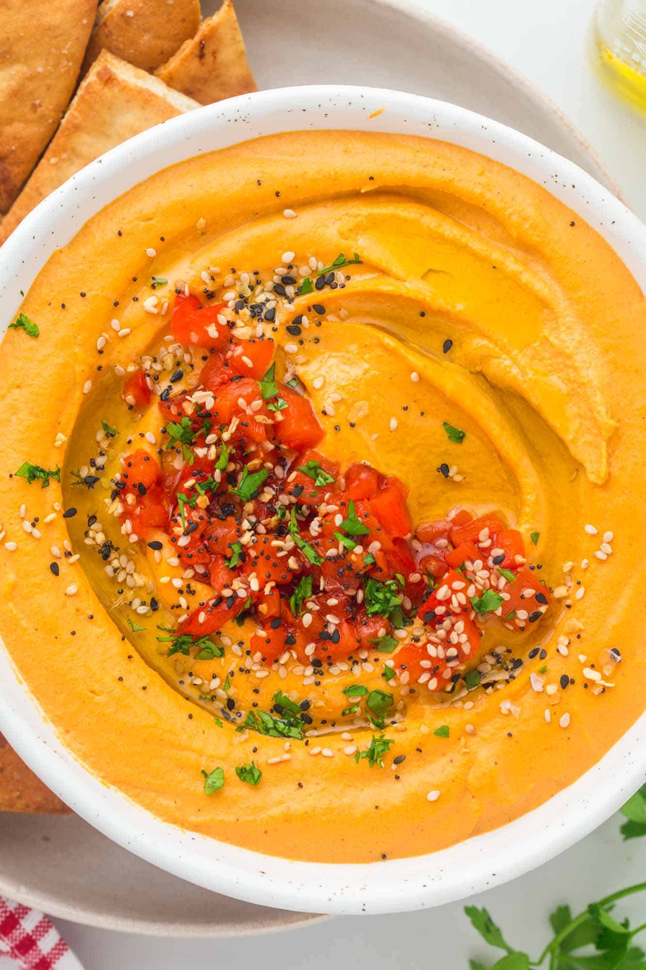 Overhead shot of roasted red pepper hummus in a white bowl