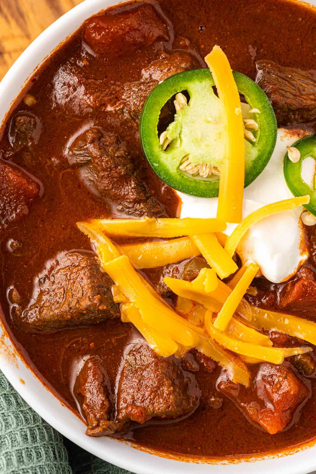 Overhead and close up shot of a bowl of texas chili with toppings