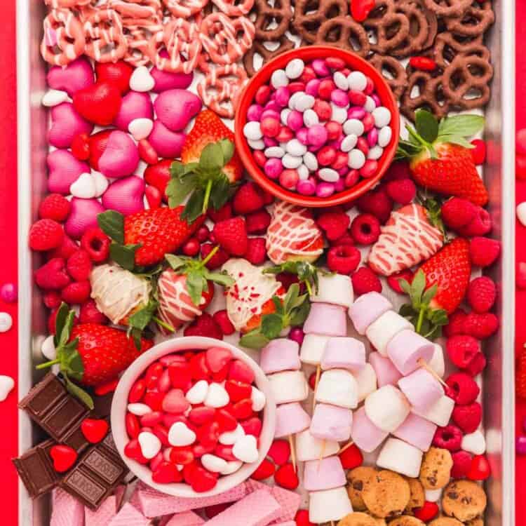 Overhead shot of Valentine’s Day Dessert Board that includes candy, fruit, pretzels, wafers, cookies, marshmallows, and chocolates.