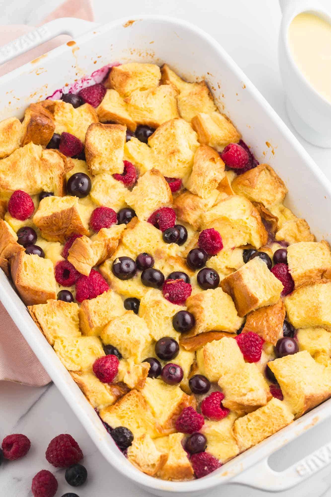 Overhead shot of berry bread pudding in a white baking dish