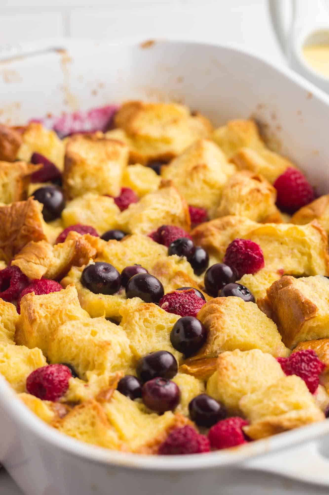 Close up shot of baked bread pudding with fresh berries