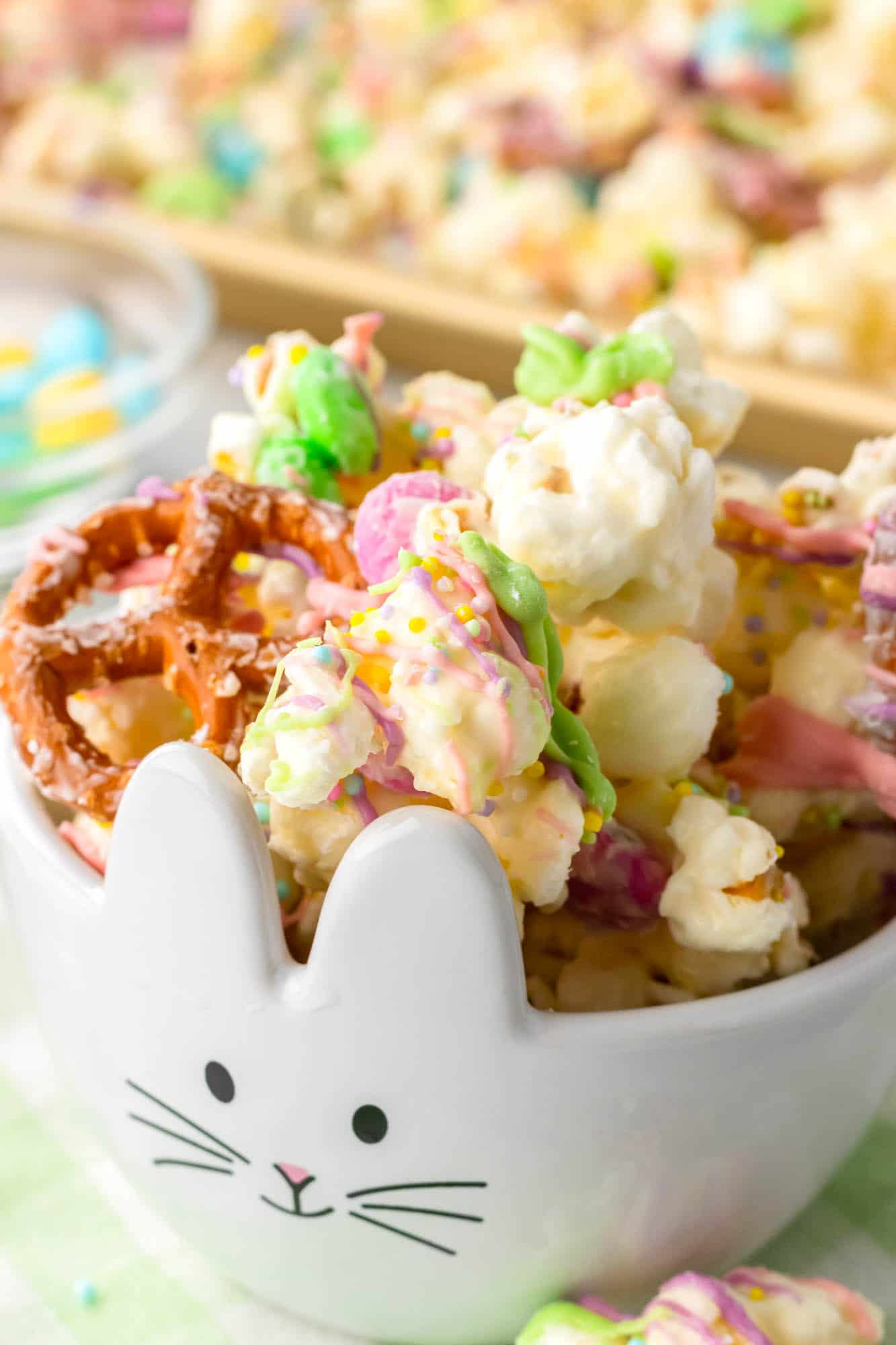 a small bunny bowl filled with homemade bunny bait made with popcorn and pretzels and easter m&ms