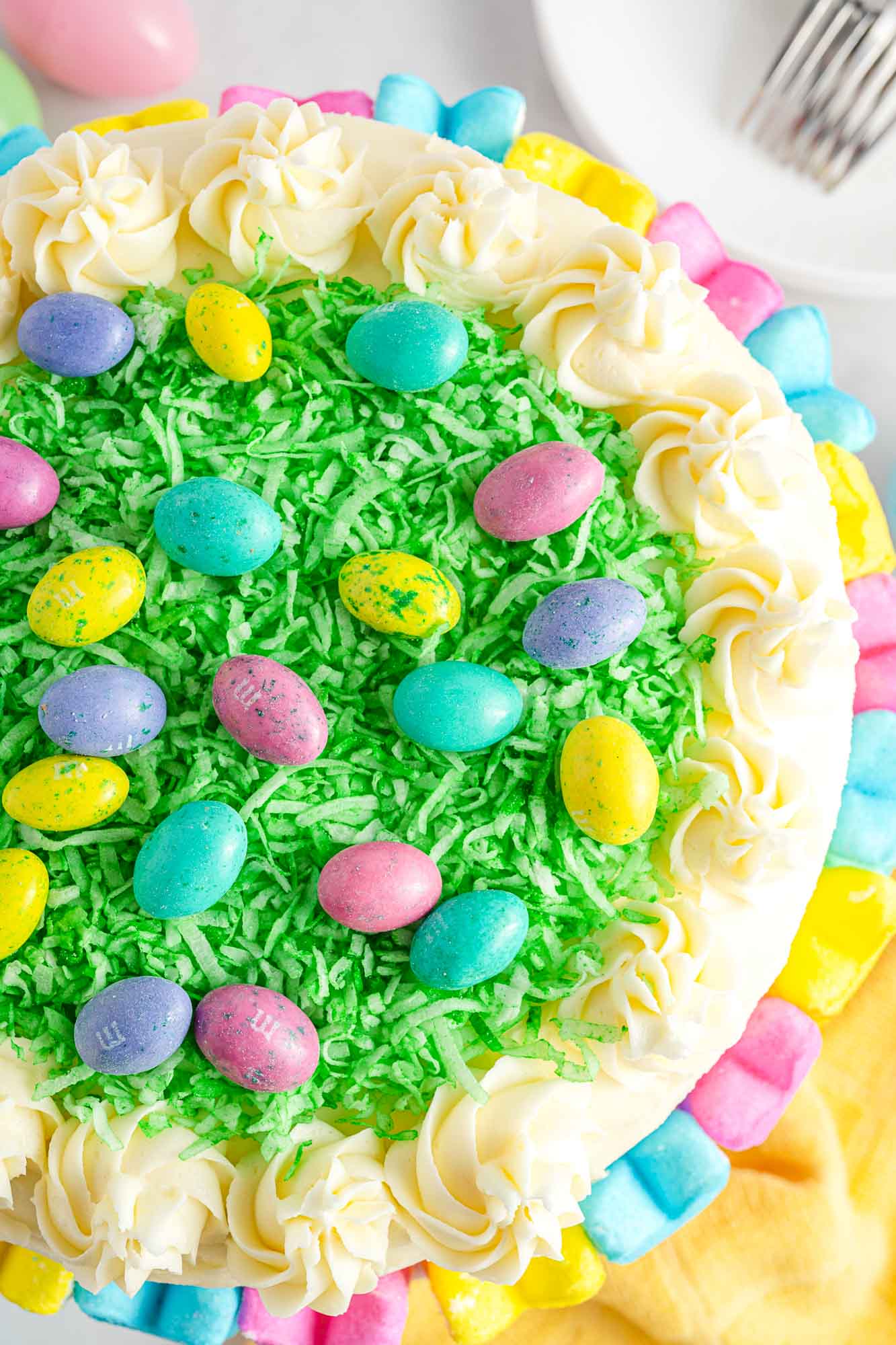 Overhead shot of an Easter cake with green coconut grass and M&M's Easter eggs.