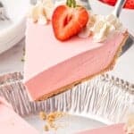 a large slice of no bake strawberry pie is being lifted from the pan with a cake server.