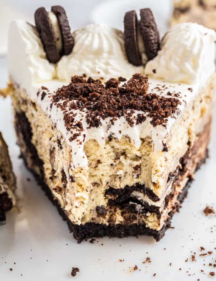 A slice of a baked Oreo cheesecake, showing a bite shot.
