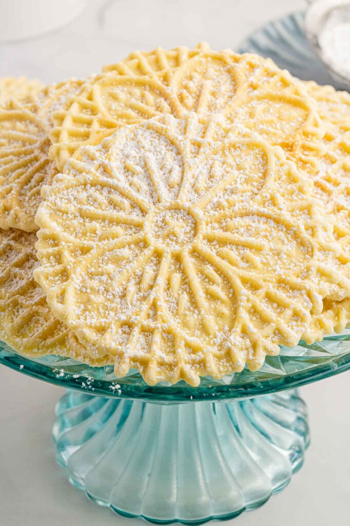a small glass cake pedestal filled with vanilla pizzelles