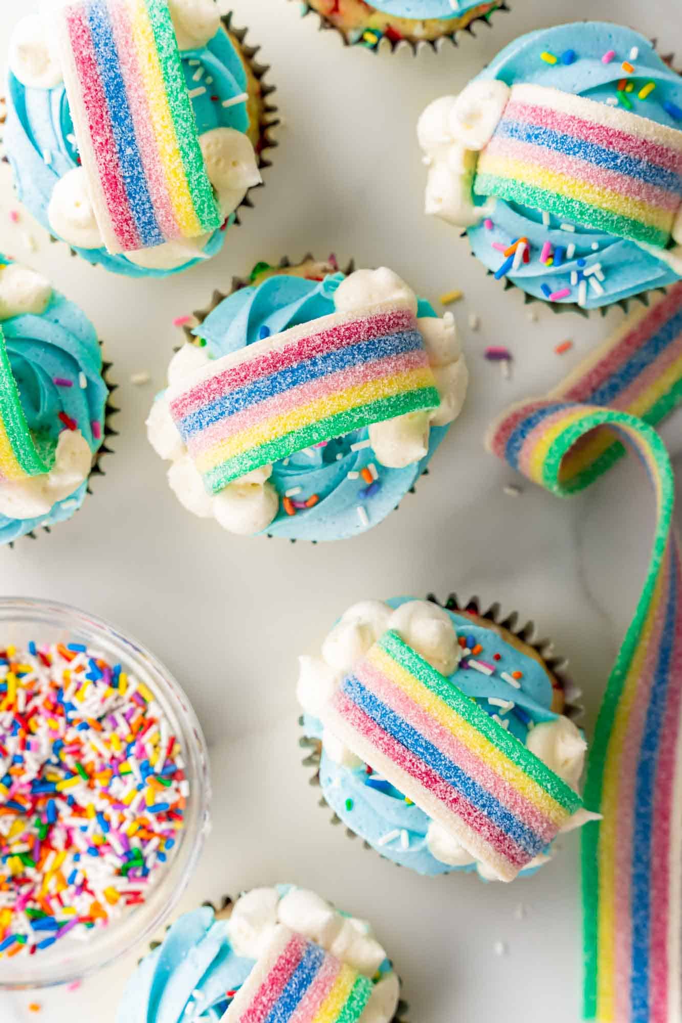 Overhead shot of rainbow cupcakes and sprinkles