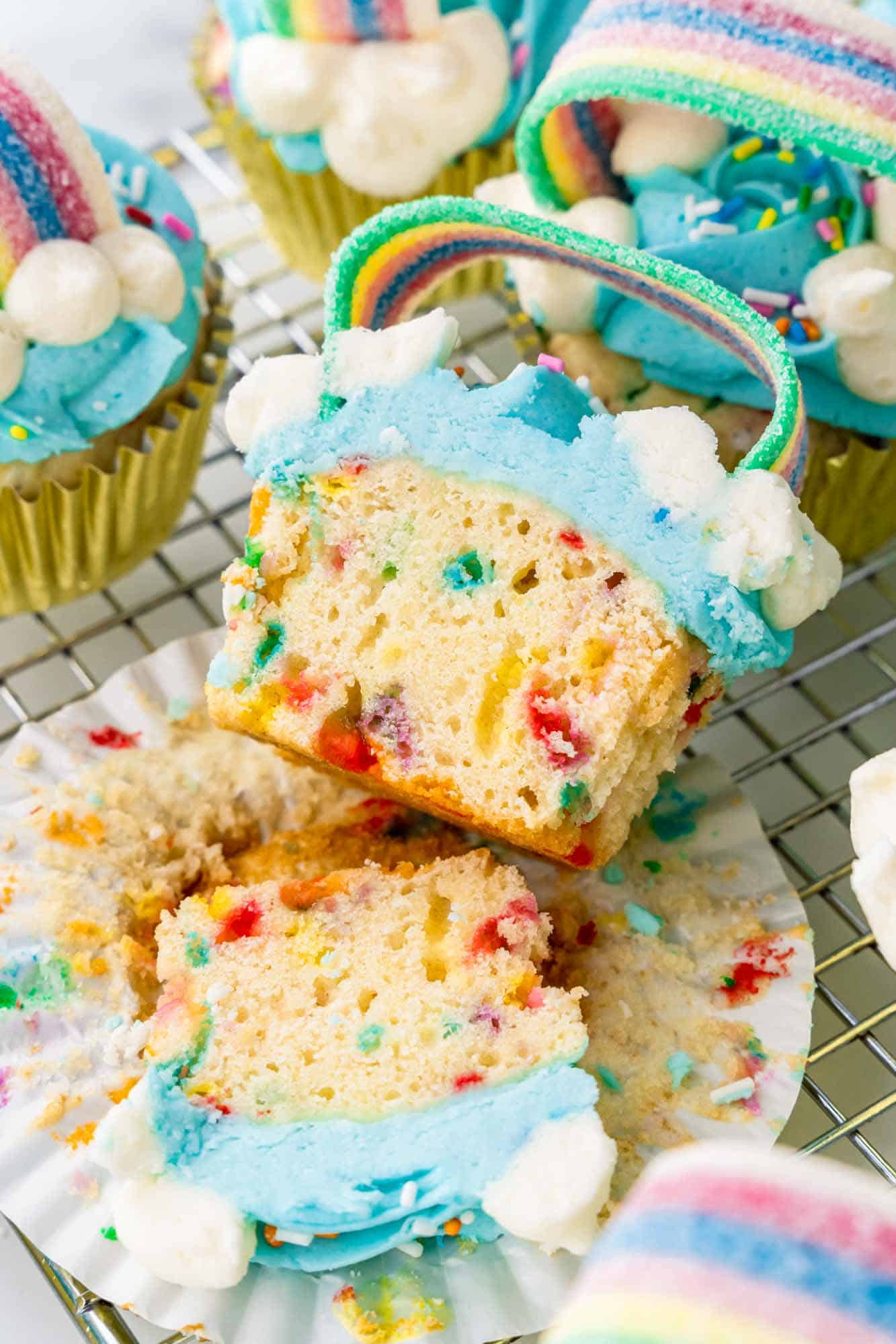 Sliced rainbow cupcake to show the funfetti in the center of the cupcake