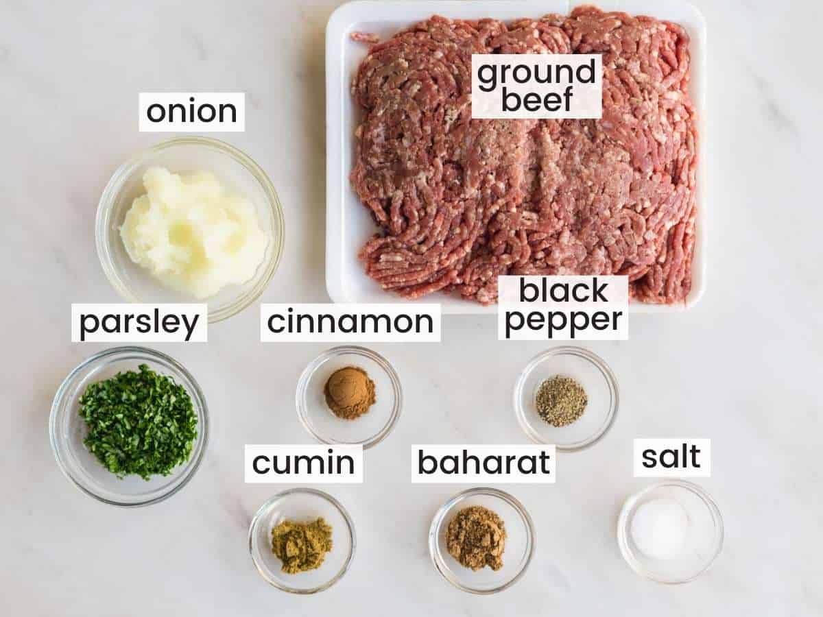 ingredients needed to make beef kafta including ground beef, parsley, onion, baharat, cinnamon, cumin, salt and pepper.