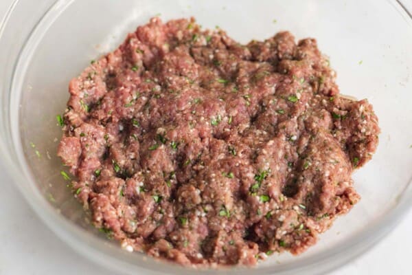 Ground beef kafta mixture with chopped parsley, onion, and spices in a bowl