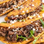 Stuffed birria tacos topped with cotija cheese and fresh cilantro