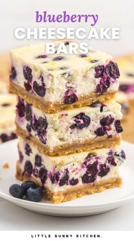 a stack of three thick blueberry cheesecake bars on a white plate. Text at top of photo