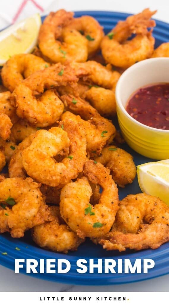 a plate of fried crispy shrimp garnished with lemons and a side cup of red sauce Text at bottom of images says Fried Shrimp in capital letters