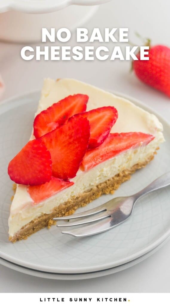 a slice of no bake cheesecake topped with sliced strawberries on a dessert plate with a silver fork