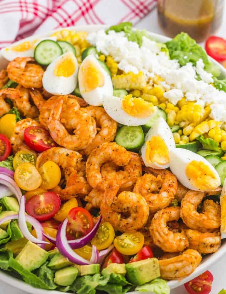 a large salad bowl filled with shrimp cobb salad