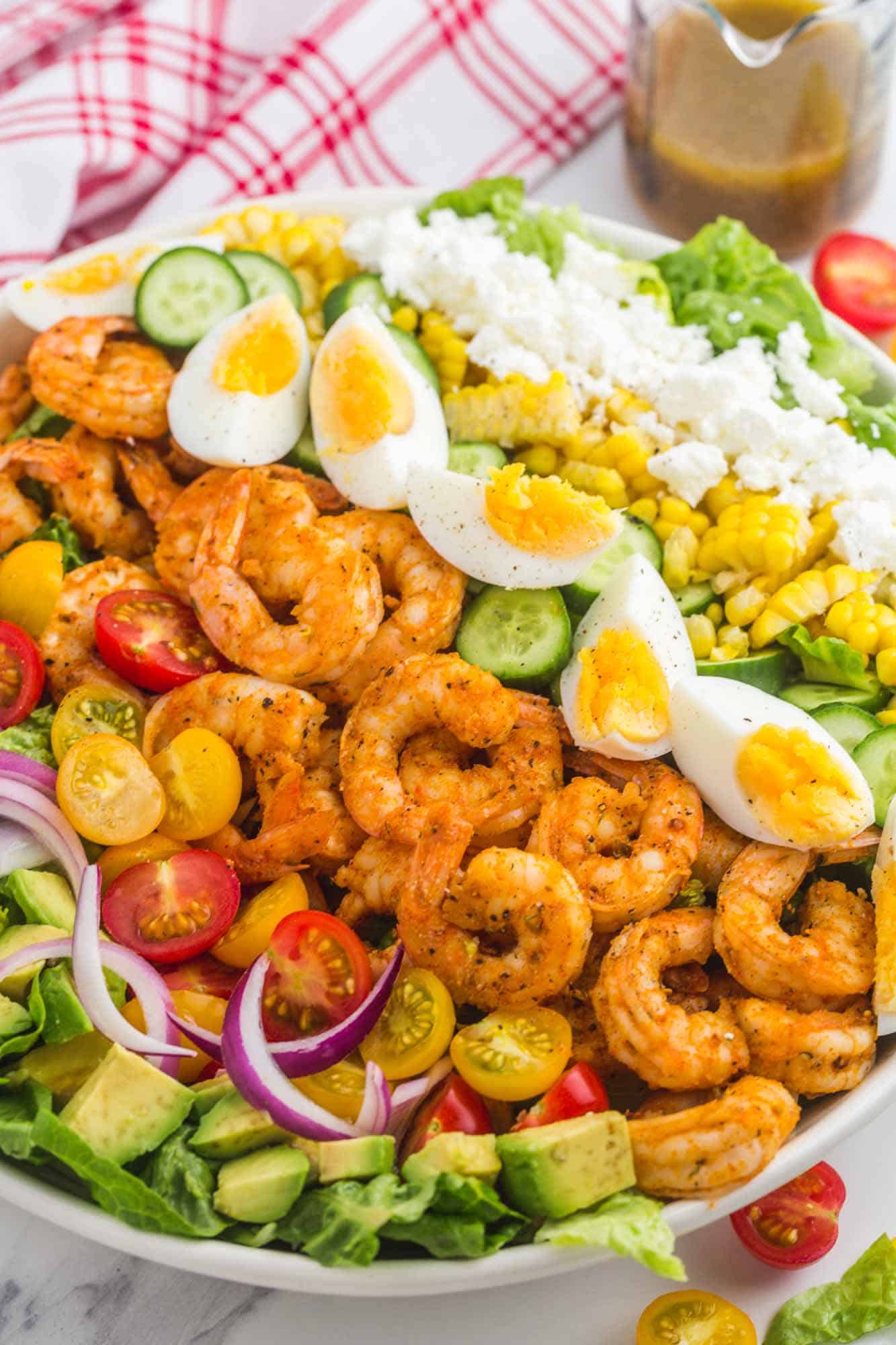 a large salad bowl filled with shrimp cobb salad