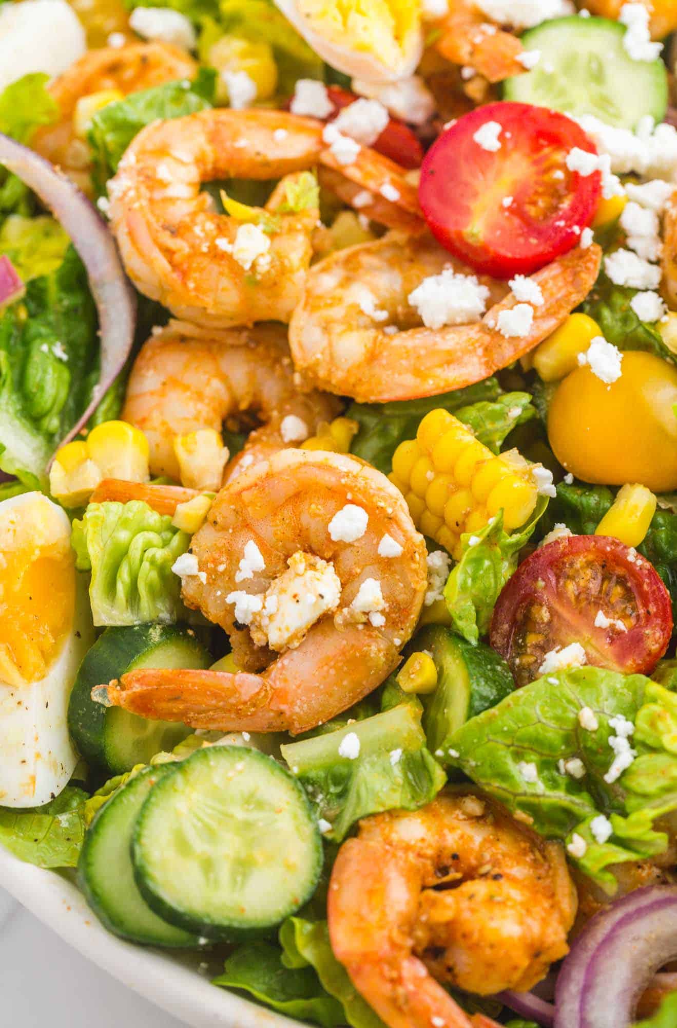 Closeup view of a shrimp cobb salad after tossing with dressing