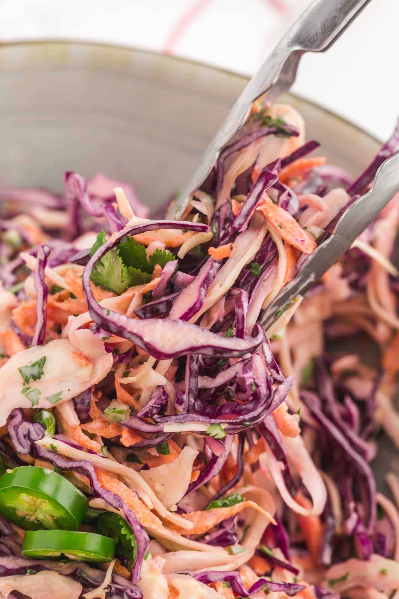 closeup image of fish taco slaw being served with tongs