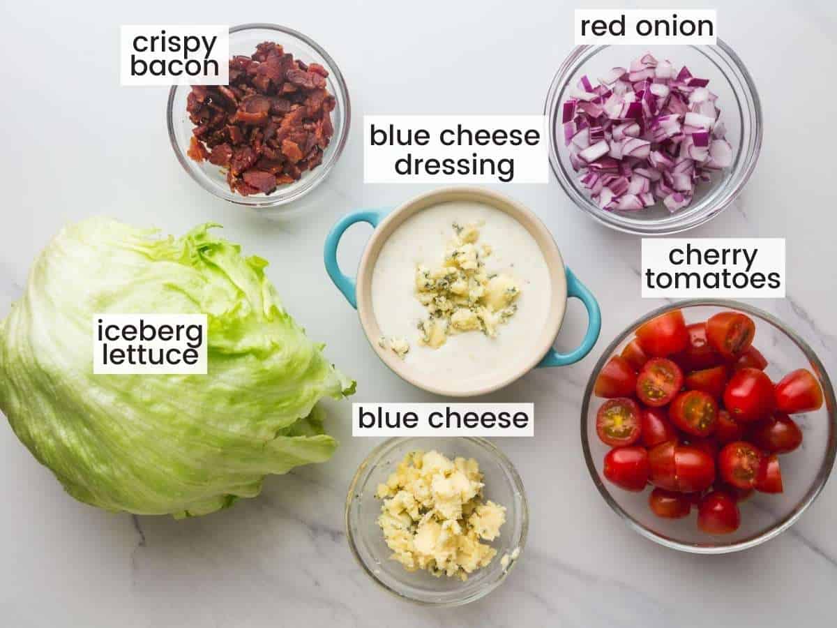 The ingredients in Wedge salad measured out into separate bowls on a marble countertop.