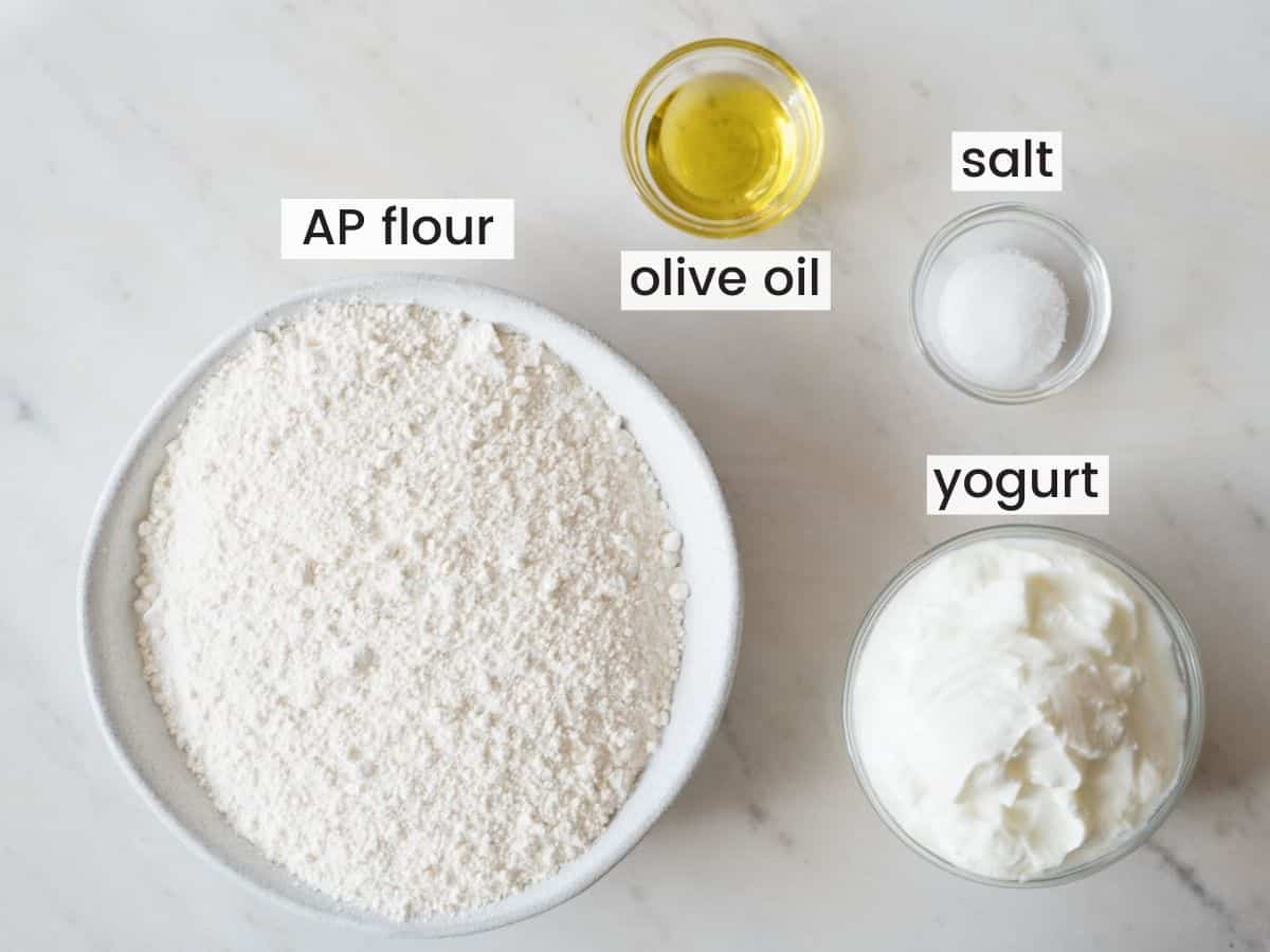 Ingredients needed for making yogurt flatbreads including flour, yogurt, salt, and olive oil.