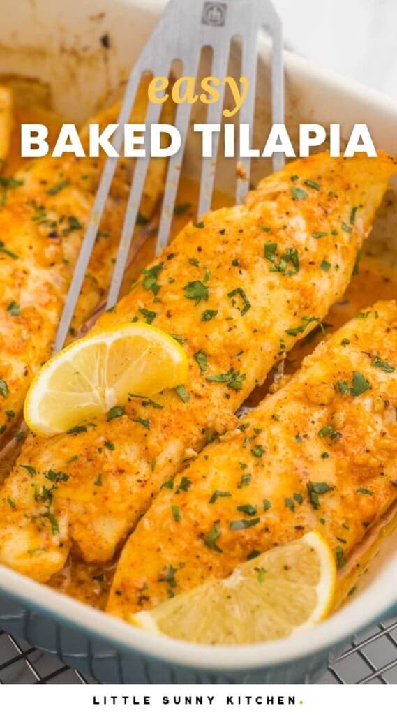 a casserole dish of baked tilapia fillets, garnished with lemon wedges. A fish flipper is lifting up a fillet.Text overlay says Baked Tilapia