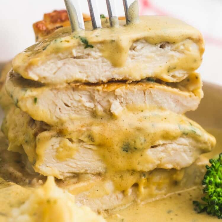 a stack of four sliced boursin chicken cutlets, held by a fork.