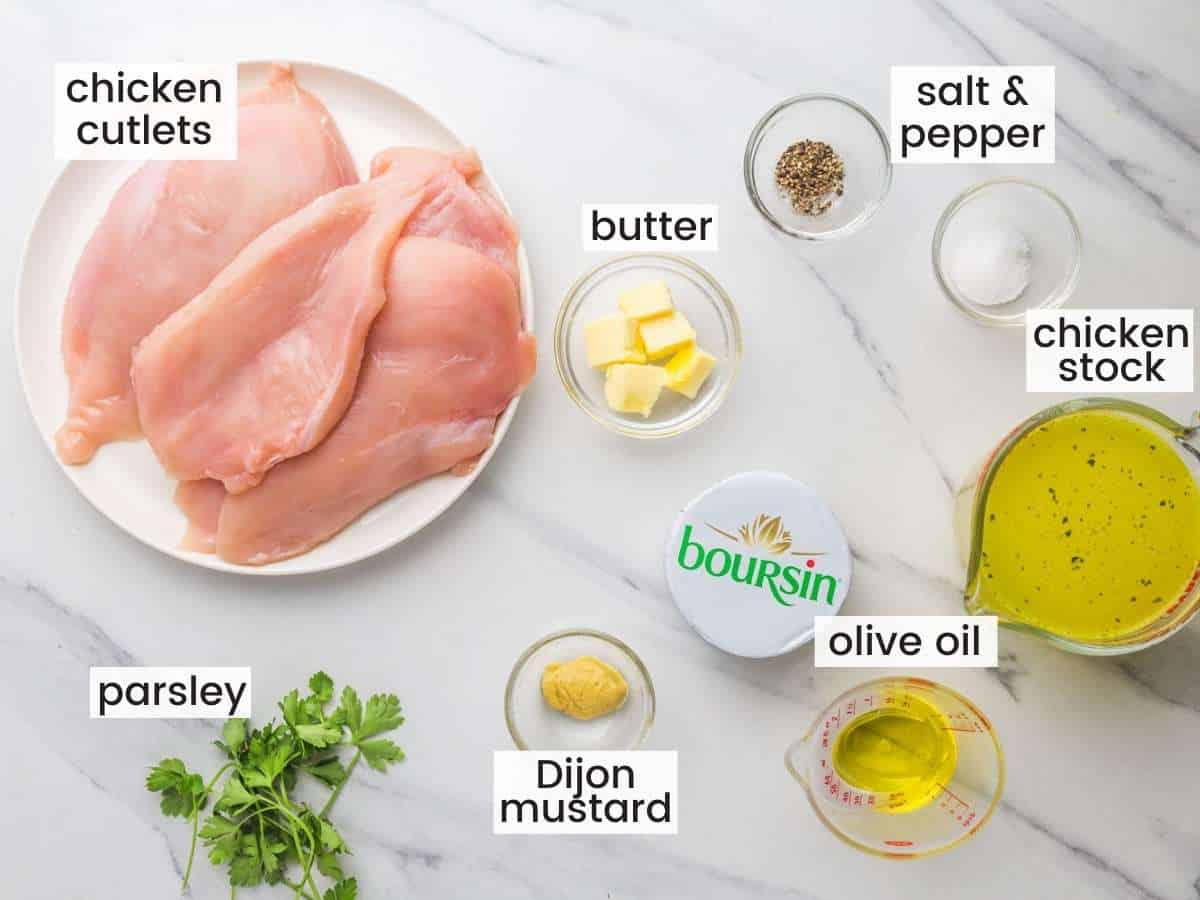 The ingredients for making creamy Boursin chicken, all measured out on a marble countertop, viewed from above
